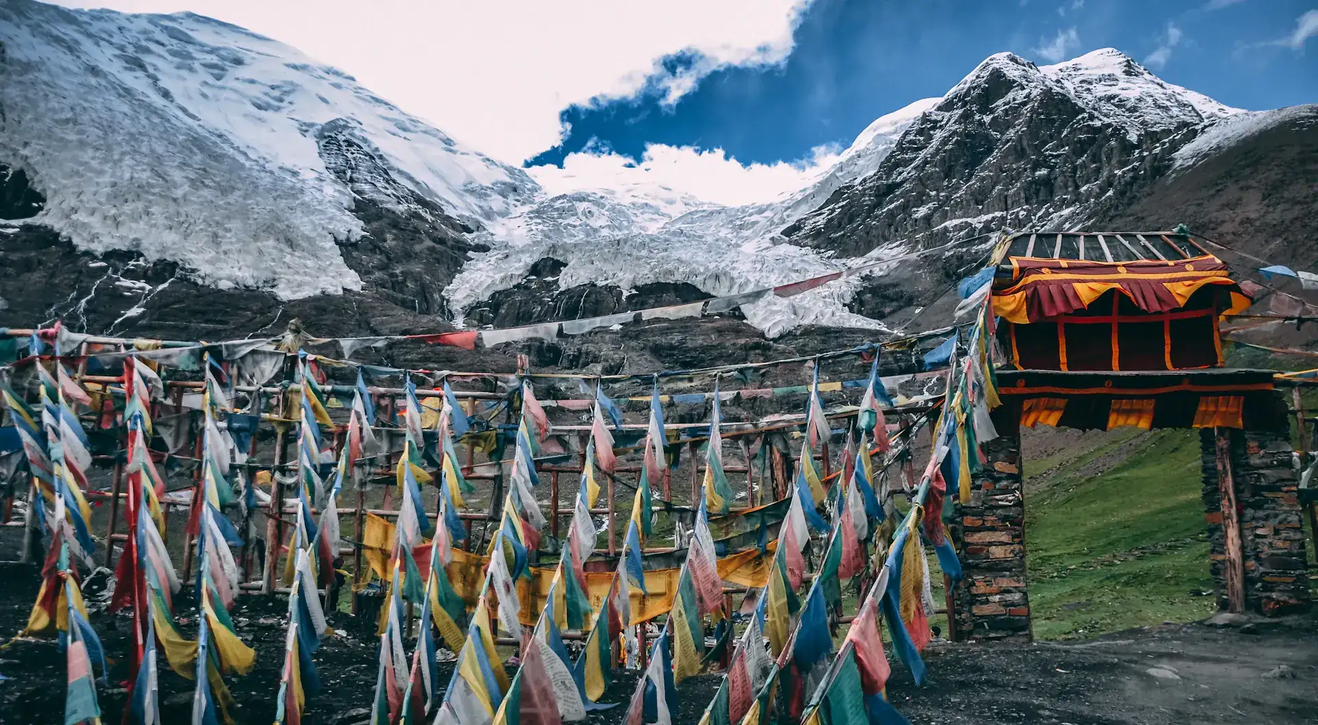 Gebetsfahnen vor schneebedeckten Gipfeln in Tibet