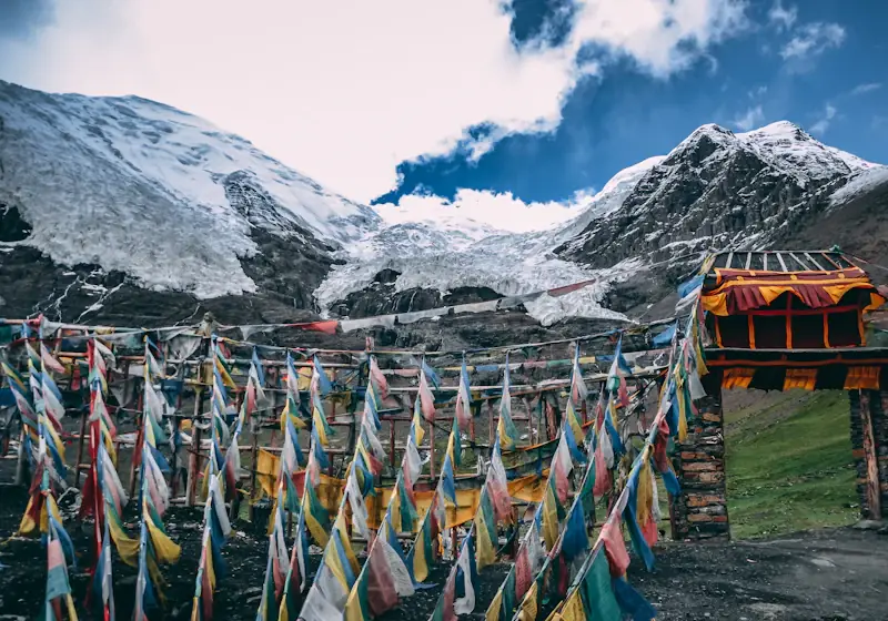 Gebetsfahnen vor schneebedeckten Gipfeln in Tibet